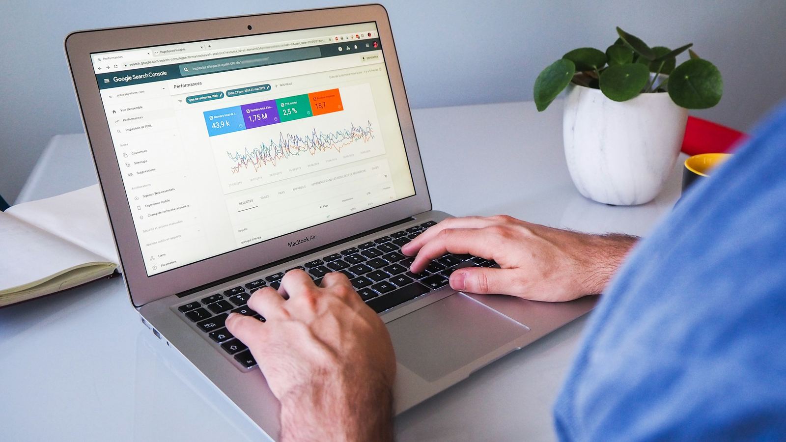 Person working on a laptop showing a Google Search Console performance report.